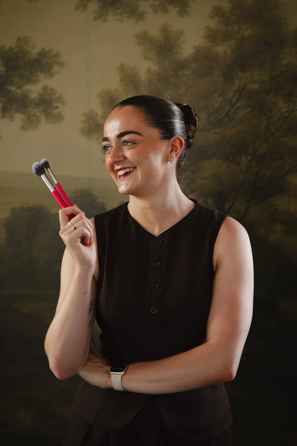 Beth Henry smiling with makeup brushes
