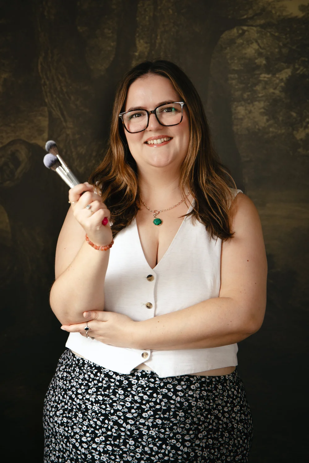 Vicky Jiggens holding makeup brushes in the studio
